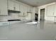 Spacious kitchen featuring white cabinets, a large island, and modern stainless steel appliances, with seamless flow into other rooms at 17168 W Middlebury St, Surprise, AZ 85388