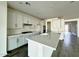 Bright and open kitchen featuring a large island, white cabinets, stainless steel appliances, and a view into the adjacent living space at 17168 W Middlebury St, Surprise, AZ 85388