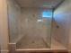 Enjoy this glass shower with sleek marble-look tile, built-in bench, and modern fixtures at 17168 W Middlebury St, Surprise, AZ 85388