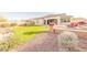 Manicured backyard featuring artificial turf, a decorative gravel area, and desert landscaping at 18322 W Thistle Landing Dr, Goodyear, AZ 85338