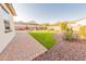 Landscaped backyard features desert plants, manicured lawn, and paver patio, perfect for outdoor enjoyment at 18322 W Thistle Landing Dr, Goodyear, AZ 85338