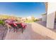 Resort-style backyard with brick patio, fire pit, and lush landscaping and lounge chairs at 18322 W Thistle Landing Dr, Goodyear, AZ 85338