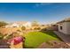 Well-manicured backyard with decorative water feature, desert landscaping, and an artificial lawn at 18322 W Thistle Landing Dr, Goodyear, AZ 85338