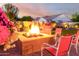 Outdoor living space with fire pit, seating, and manicured landscaping for relaxation at 18322 W Thistle Landing Dr, Goodyear, AZ 85338