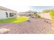 Beautiful backyard features desert landscaping and a manicured lawn, offering a tranquil outdoor space at 18322 W Thistle Landing Dr, Goodyear, AZ 85338