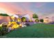 Backyard with illuminated rock waterfall feature and manicured artificial lawn at 18322 W Thistle Landing Dr, Goodyear, AZ 85338