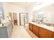 Bathroom with double sink vanity, granite countertops, tile flooring, and a walk-in shower at 18322 W Thistle Landing Dr, Goodyear, AZ 85338