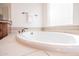 Luxurious bathtub with tile surround and elegant fixtures in a bright bathroom at 18322 W Thistle Landing Dr, Goodyear, AZ 85338