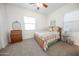 Neutral-toned bedroom features a ceiling fan, patterned bedding, and lots of light at 18322 W Thistle Landing Dr, Goodyear, AZ 85338