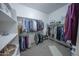 Organized walk-in closet featuring ample hanging space, shelving, and a carpeted floor at 18322 W Thistle Landing Dr, Goodyear, AZ 85338