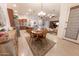 Open-concept kitchen and dining area with stainless steel appliances and adjacent living room at 18322 W Thistle Landing Dr, Goodyear, AZ 85338