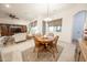 Dining area has a wood table with four chairs, a ceiling fan, and is open to the living area at 18322 W Thistle Landing Dr, Goodyear, AZ 85338