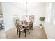 Bright dining room with carpet flooring, a modern chandelier, and a large window at 18322 W Thistle Landing Dr, Goodyear, AZ 85338