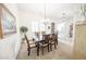 Elegant dining room with neutral decor, a wooden table with chairs, and ample natural light at 18322 W Thistle Landing Dr, Goodyear, AZ 85338
