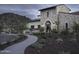 Elegant stone clubhouse with desert landscaping, pathway, and architectural details creating a welcoming entrance at 18322 W Thistle Landing Dr, Goodyear, AZ 85338