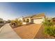 Attractive home with desert landscaping, a tile roof, and a brick paver driveway at 18322 W Thistle Landing Dr, Goodyear, AZ 85338