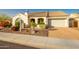 Charming single-story home featuring a tile roof, desert landscaping, and a brick paver driveway at 18322 W Thistle Landing Dr, Goodyear, AZ 85338