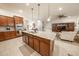 Open kitchen with island, stainless appliances, and ample cabinet space overlooks the living room at 18322 W Thistle Landing Dr, Goodyear, AZ 85338