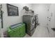 This laundry room includes stainless steel washer and dryer, tile floors, and a white door at 18322 W Thistle Landing Dr, Goodyear, AZ 85338