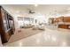 Spacious living room open to the kitchen, with neutral tones and abundant natural light at 18322 W Thistle Landing Dr, Goodyear, AZ 85338