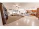 Open-concept living space features plush carpet and elegant tile flooring adjacent to the kitchen at 18322 W Thistle Landing Dr, Goodyear, AZ 85338