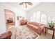 Cozy living room with a patterned sofa, piano, area rug, and arched window at 18322 W Thistle Landing Dr, Goodyear, AZ 85338