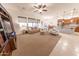 Spacious living room features a ceiling fan and large windows with custom shades at 18322 W Thistle Landing Dr, Goodyear, AZ 85338