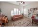 Bright living room with an arched window, shutters, decorative shelving, and area rug at 18322 W Thistle Landing Dr, Goodyear, AZ 85338