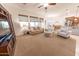 Bright living room with plush seating, a ceiling fan, and abundant natural light at 18322 W Thistle Landing Dr, Goodyear, AZ 85338