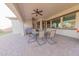 Covered patio with ample light, beautiful brick floors, and an outdoor dining set at 18322 W Thistle Landing Dr, Goodyear, AZ 85338