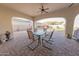 Covered patio with brick flooring, ceiling fan, and views of a landscaped backyard at 18322 W Thistle Landing Dr, Goodyear, AZ 85338