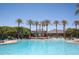 Community pool with palm tree lined edge and lounge chairs at 18322 W Thistle Landing Dr, Goodyear, AZ 85338