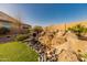 A serene rock water feature adds beauty to this lushly landscaped outdoor space at 18322 W Thistle Landing Dr, Goodyear, AZ 85338
