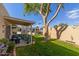 Relaxing backyard featuring a covered patio with seating and mature landscaping at 18745 N 92Nd Dr, Peoria, AZ 85382