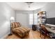 Bedroom featuring sleek wood floors, natural light, and a decorative chaise lounge at 18745 N 92Nd Dr, Peoria, AZ 85382