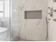 Modern bathroom featuring a frameless glass shower with marble tile and a built-in niche for toiletries at 18860 N 73Rd Dr, Glendale, AZ 85308