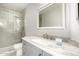 Bathroom with stone countertop, vanity and sink, and glass-enclosed shower with a gray tiled wall at 18860 N 73Rd Dr, Glendale, AZ 85308
