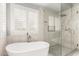 Bathroom with standalone tub, walk in shower and shuttered window at 18860 N 73Rd Dr, Glendale, AZ 85308