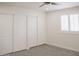 Bright bedroom with neutral carpet, shuttered window, and closet with modern sliding doors at 18860 N 73Rd Dr, Glendale, AZ 85308