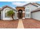 Gray two-story home featuring a stone entryway, arched windows, and a desert landscaped yard at 18860 N 73Rd Dr, Glendale, AZ 85308