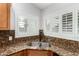 Close up on granite countertops surrounding stainless steel sink with white shuttered windows at 18860 N 73Rd Dr, Glendale, AZ 85308