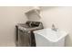 Well-lit laundry room features stainless steel washer/dryer and convenient utility sink at 18860 N 73Rd Dr, Glendale, AZ 85308