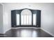 Modern living room features hardwood floors, plantation shutters, and trendy navy accent wall at 18860 N 73Rd Dr, Glendale, AZ 85308