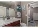 A bathroom with a dark wood vanity, a single sink, seahorse art and decorative towels at 20539 W Terrace Ln, Buckeye, AZ 85396