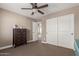 Cozy bedroom with a ceiling fan, dresser and white closet doors at 20539 W Terrace Ln, Buckeye, AZ 85396