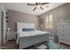 Neutral bedroom with hard wood floors, large bed, big windows with shutters, and ceiling fan at 20539 W Terrace Ln, Buckeye, AZ 85396