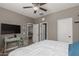 Bedroom with wooden floors, white comforter, big window with shutters, and ceiling fan at 20539 W Terrace Ln, Buckeye, AZ 85396