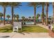 Landscaped community pool with palm trees, lounge chairs, and clear park rules at 20539 W Terrace Ln, Buckeye, AZ 85396