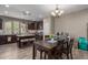 Dining area with a table, chandelier, and open view to the kitchen with island seating at 20539 W Terrace Ln, Buckeye, AZ 85396