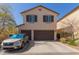 Two-story home featuring a two-car garage, simple desert landscaping, and a neutral color palette at 20539 W Terrace Ln, Buckeye, AZ 85396